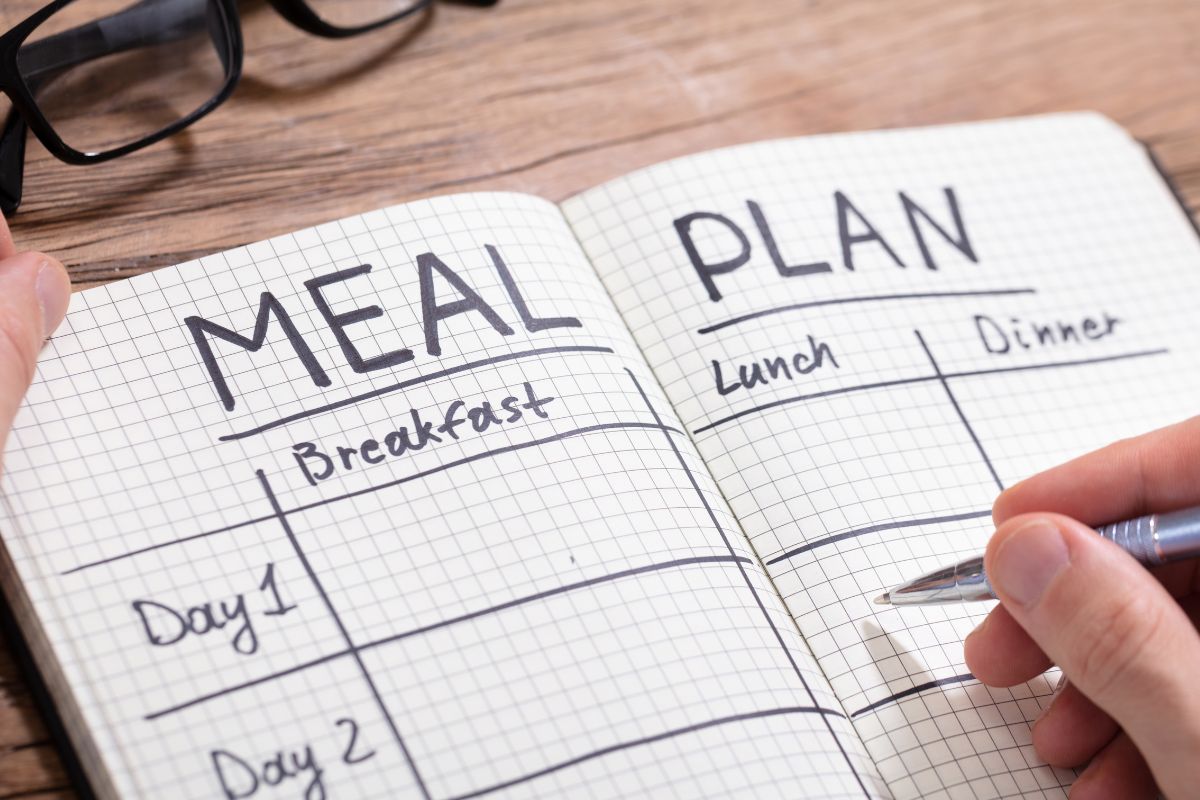 A man's hand making a planned meal.