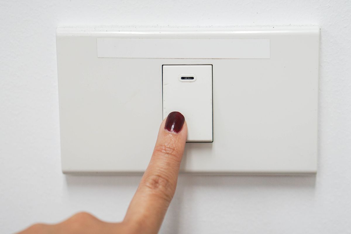 A woman's hand switches off the light.