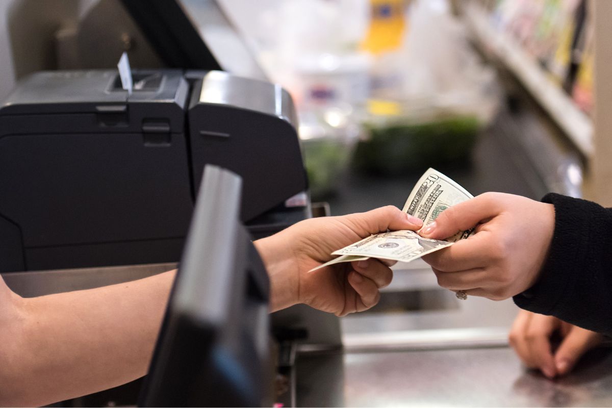 The hand of a woman paying in cash.
