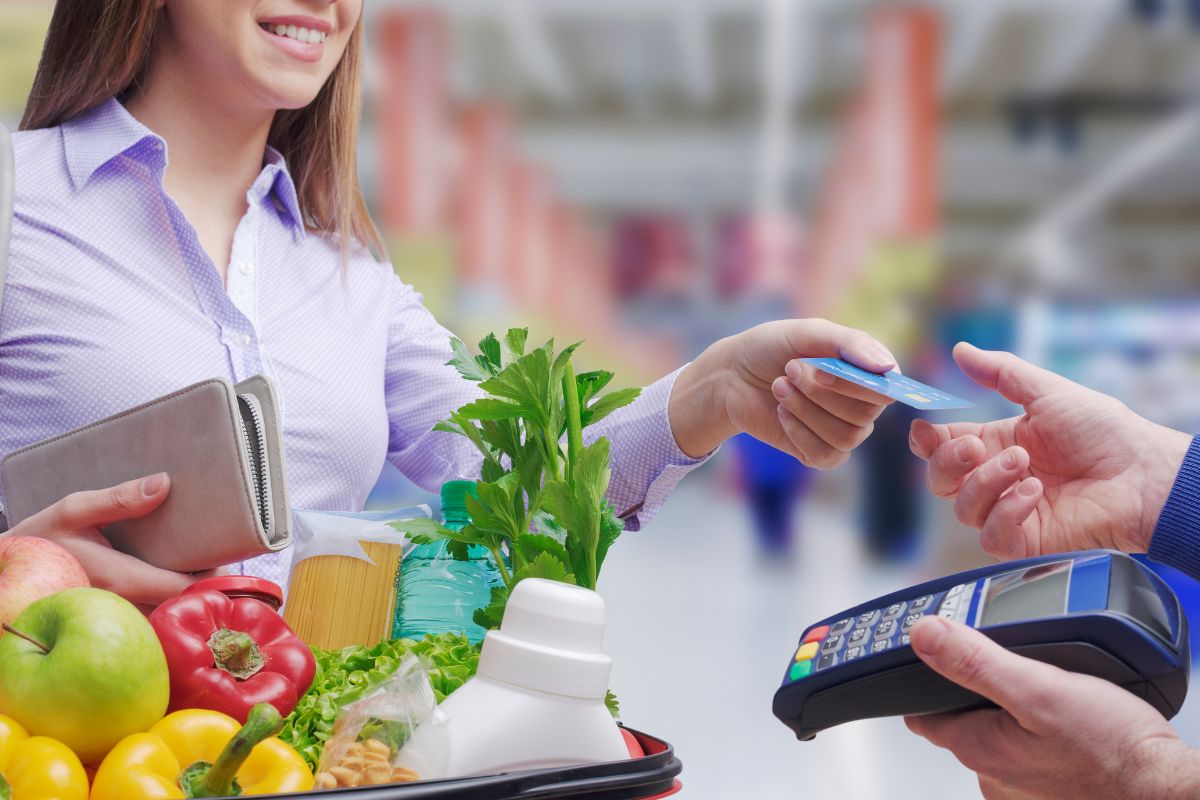 A woman paying for the groceries with a credit card.