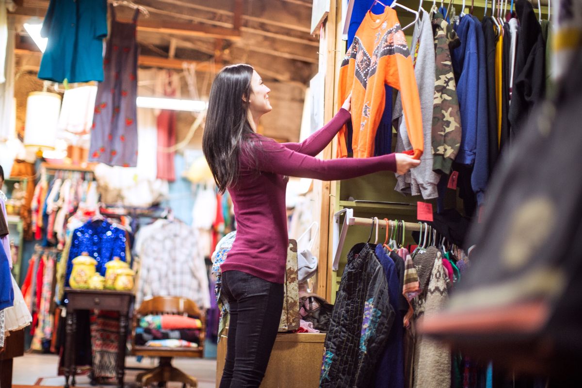 A woman shopping for clothes at a thrift store.