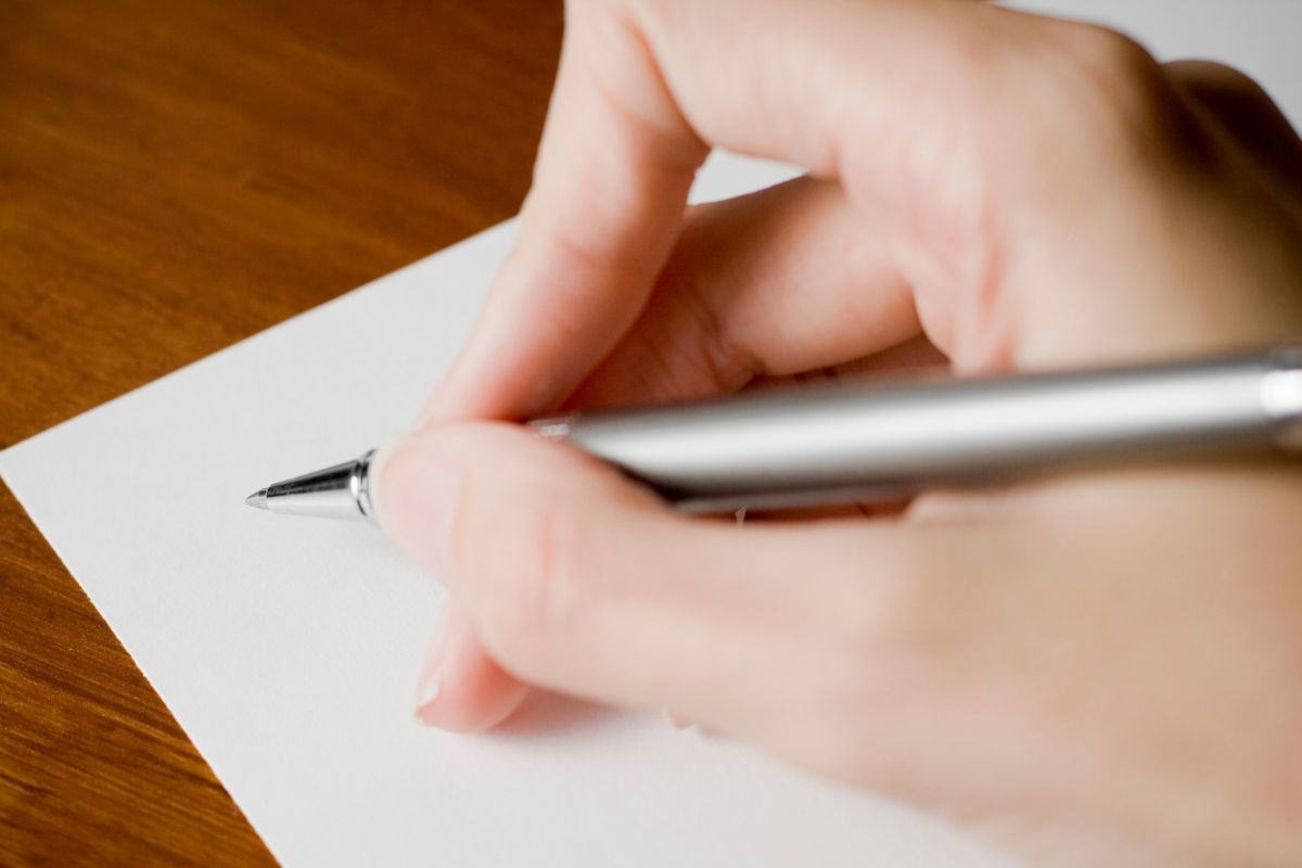 A woman's hand and writing a letter.