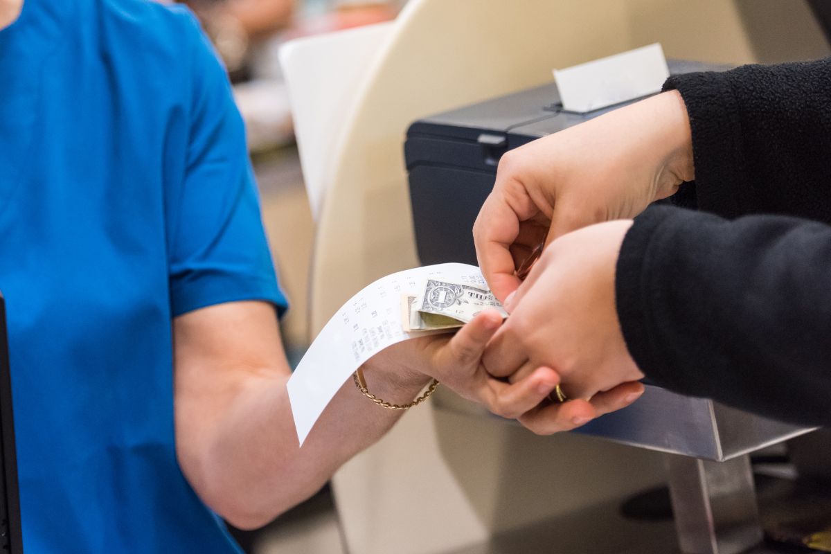 Image of a woman paying in cash.