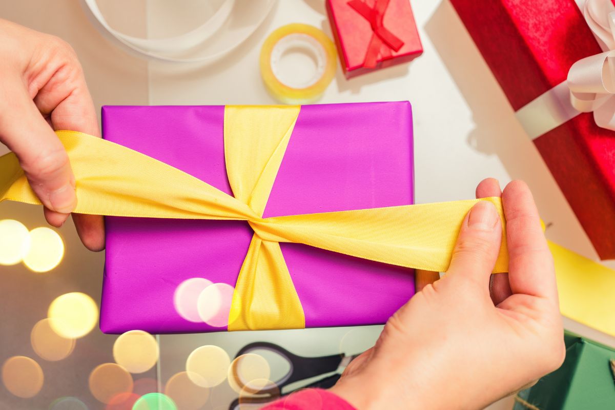 A woman's hand wrapping a gift.