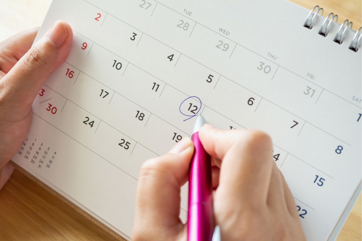 A woman's hand marking a calendar.