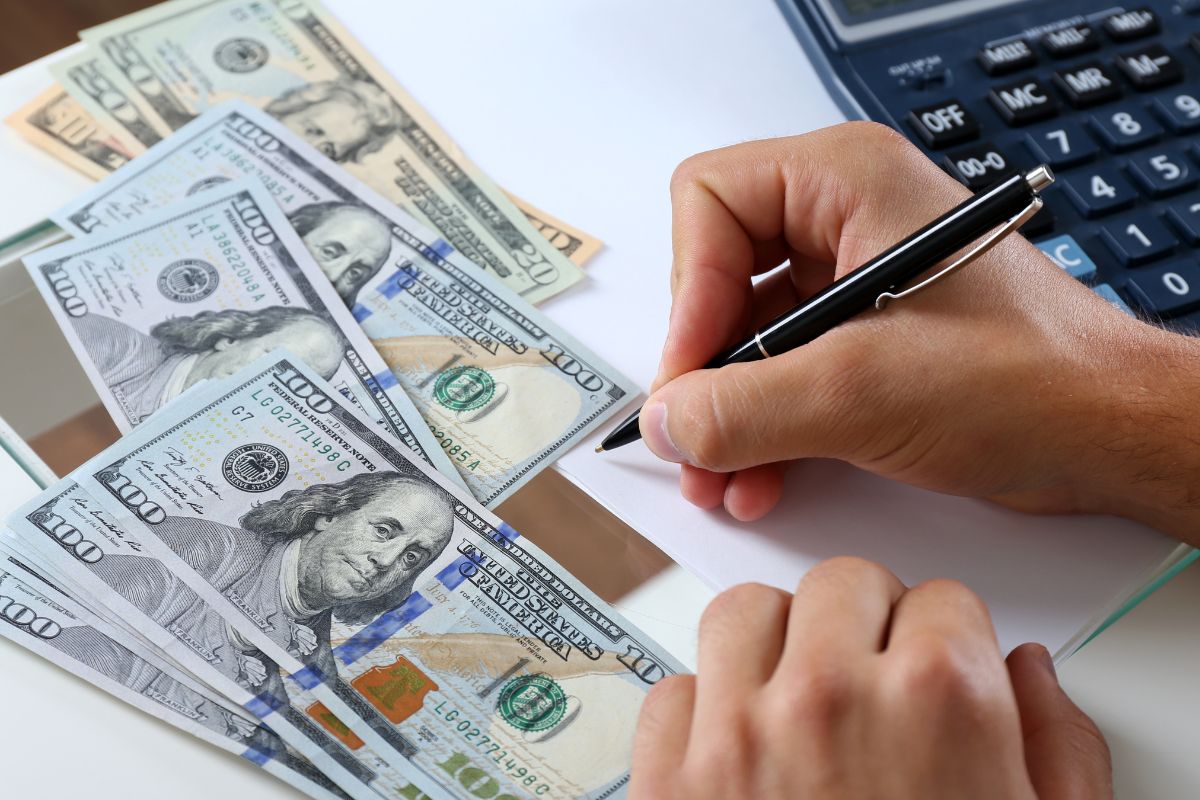A man's hand setting his financial goals.