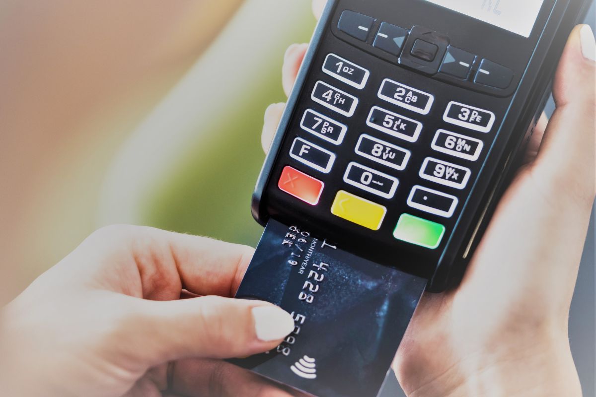 A woman's hand scanning her credit card.