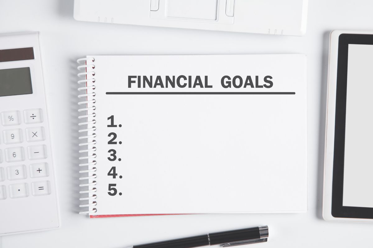 A notebook with a financial goals list.