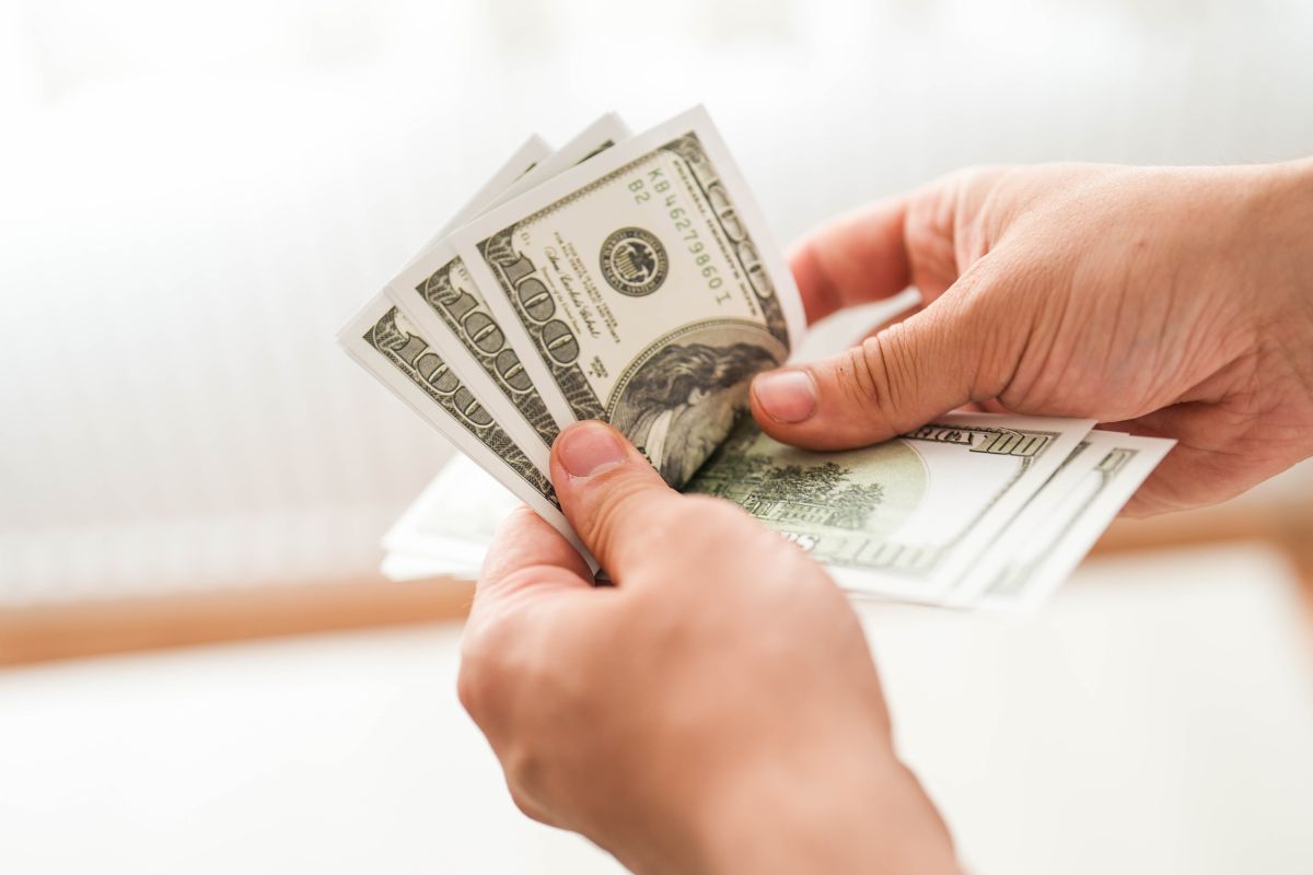 A man's hand counting money.