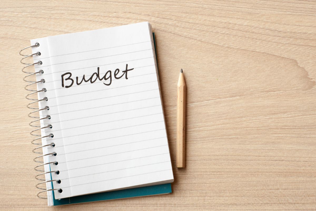 Photo of a pen and a notebook with budget wording.