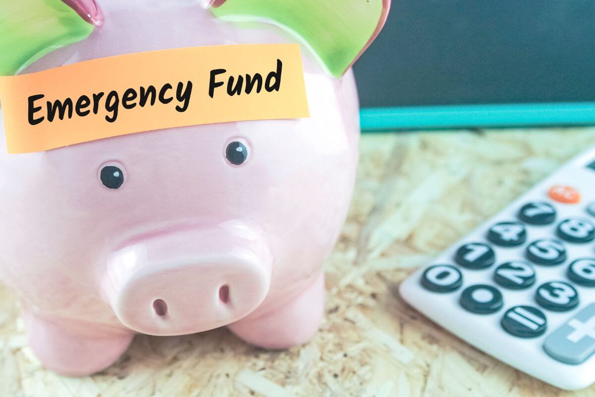The picture of a calculator and a piggy bank with a note indicating to build an emergency fund that helps cover unexpected expenses without going into debt or breaking your budget.
