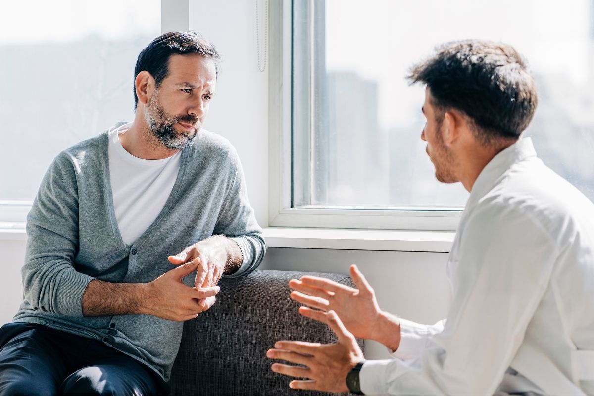 The image shows a man talking to a financial advisor.