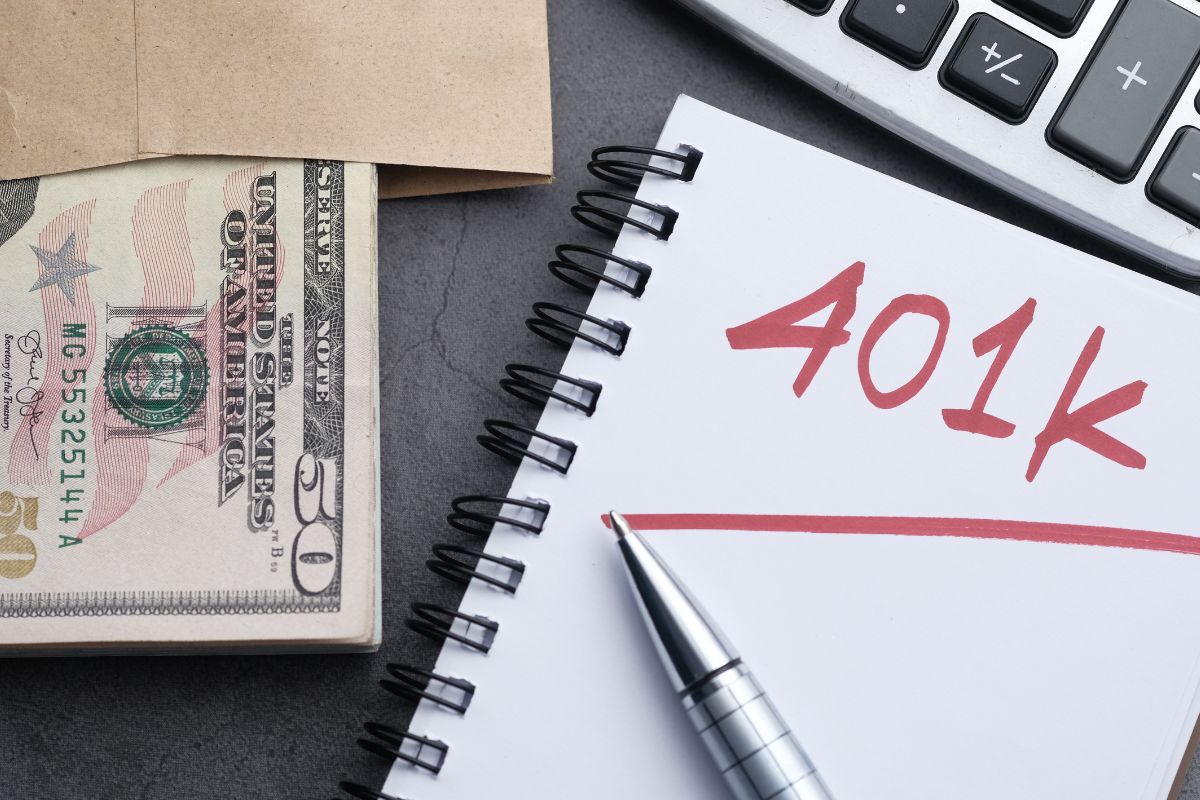 Foto de dinheiro e um caderno com redação de 401k.