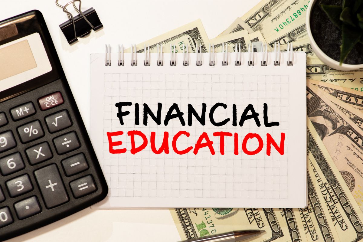 A imagem mostra um caderno com redação de educação financeira.