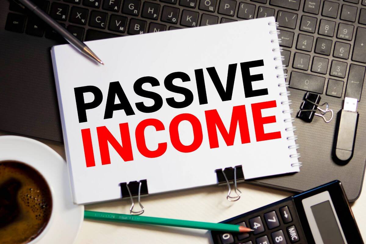 The photo shows a notebook with passive income wording.
