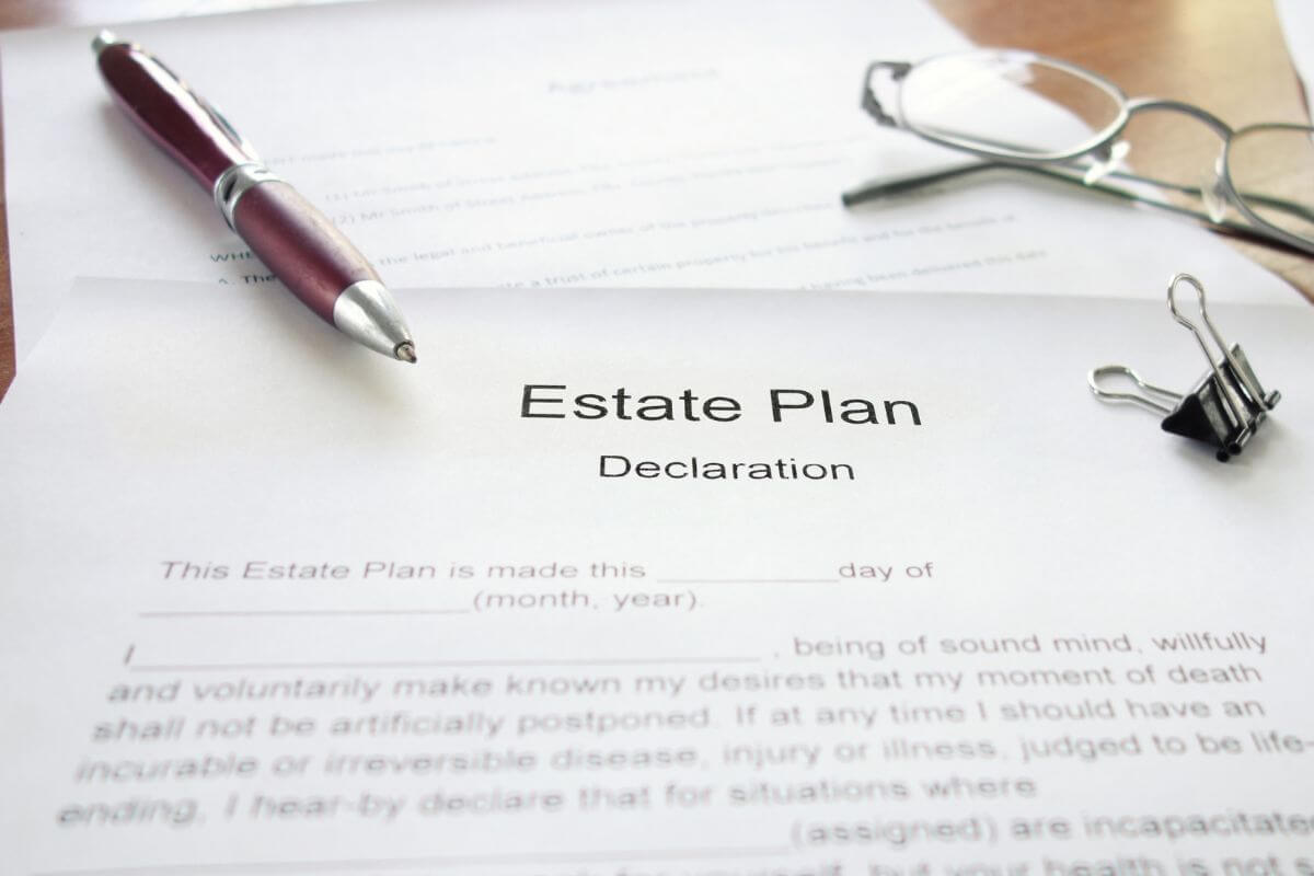 The image tells about a pen, a clip, an eyeglass, and papers with notes referring to establishing or reviewing your estate plan to ensure your wishes are followed and your loved ones are cared for.