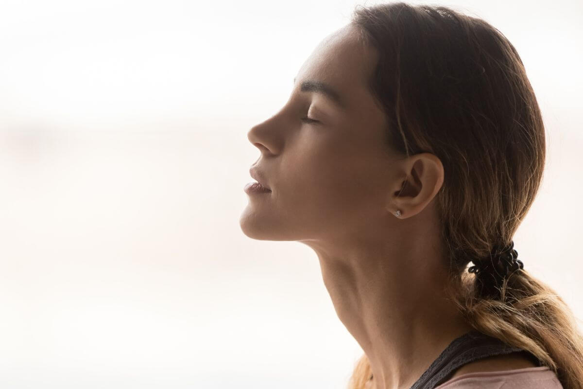 The image shows a girl closing her eyes while relaxing which means taking a deep breath helps you think clearly and focus on the steps to get your finances in order.