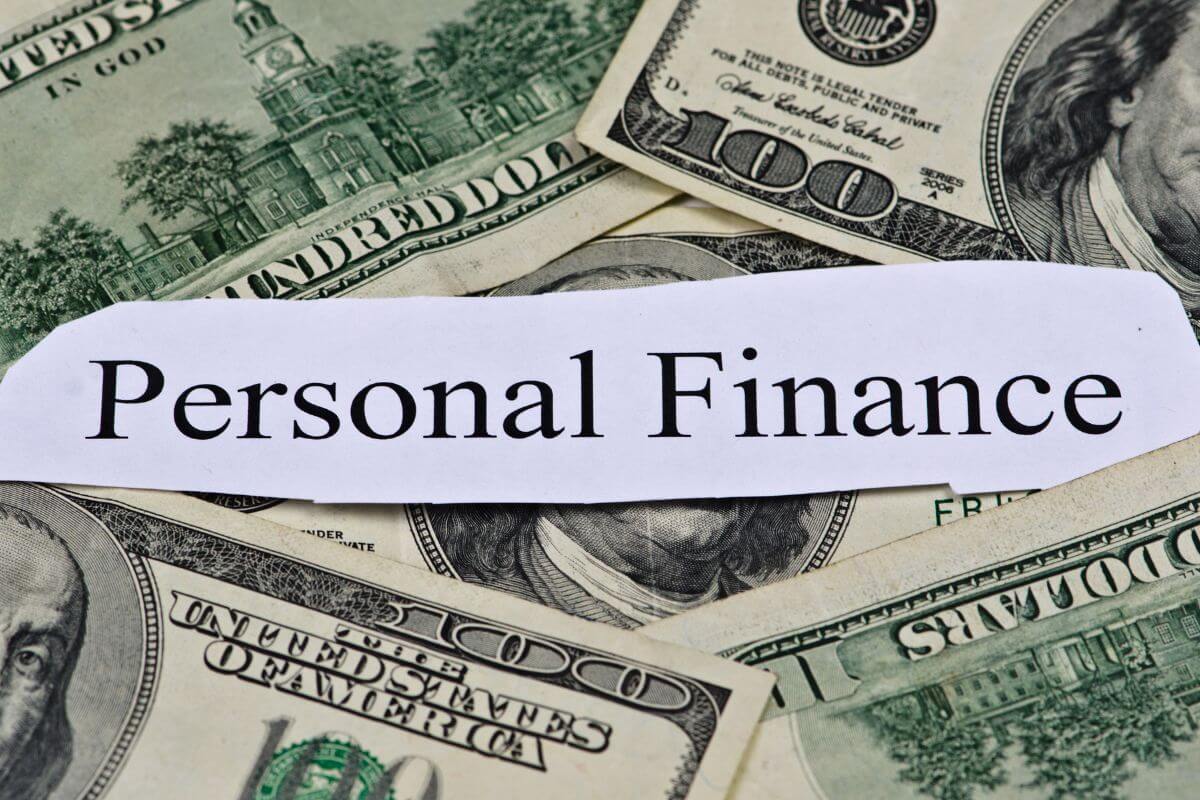 The picture shows dollar bills and a piece of paper with notes which means educating yourself on personal finance basics to feel more confident and less stressed about your financial future.