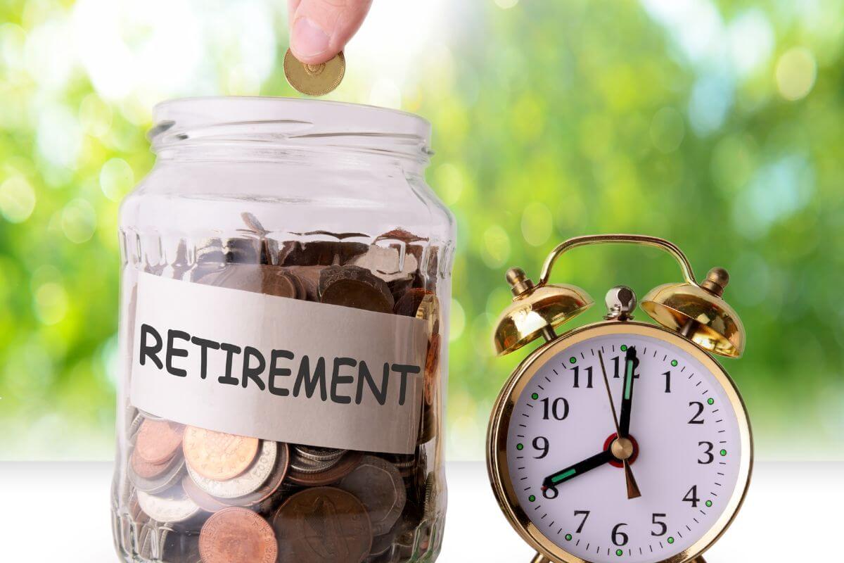 The image shows a clock and a jar filled with coins and notes which means that contributing regularly to retirement savings helps secure your futures and prepare for financial independence.