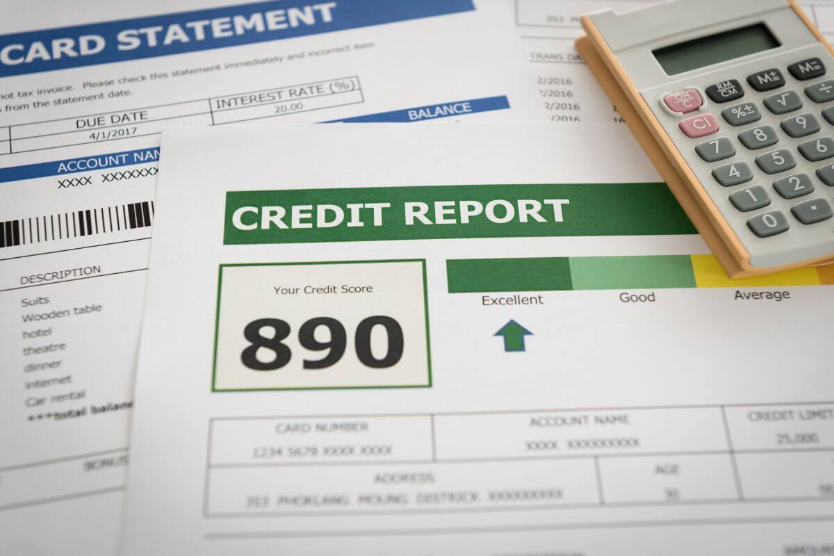 The image shows a calculator and papers with notes and a graph referring to reviewing your credit report annually helps you spot errors and monitor your financial health.