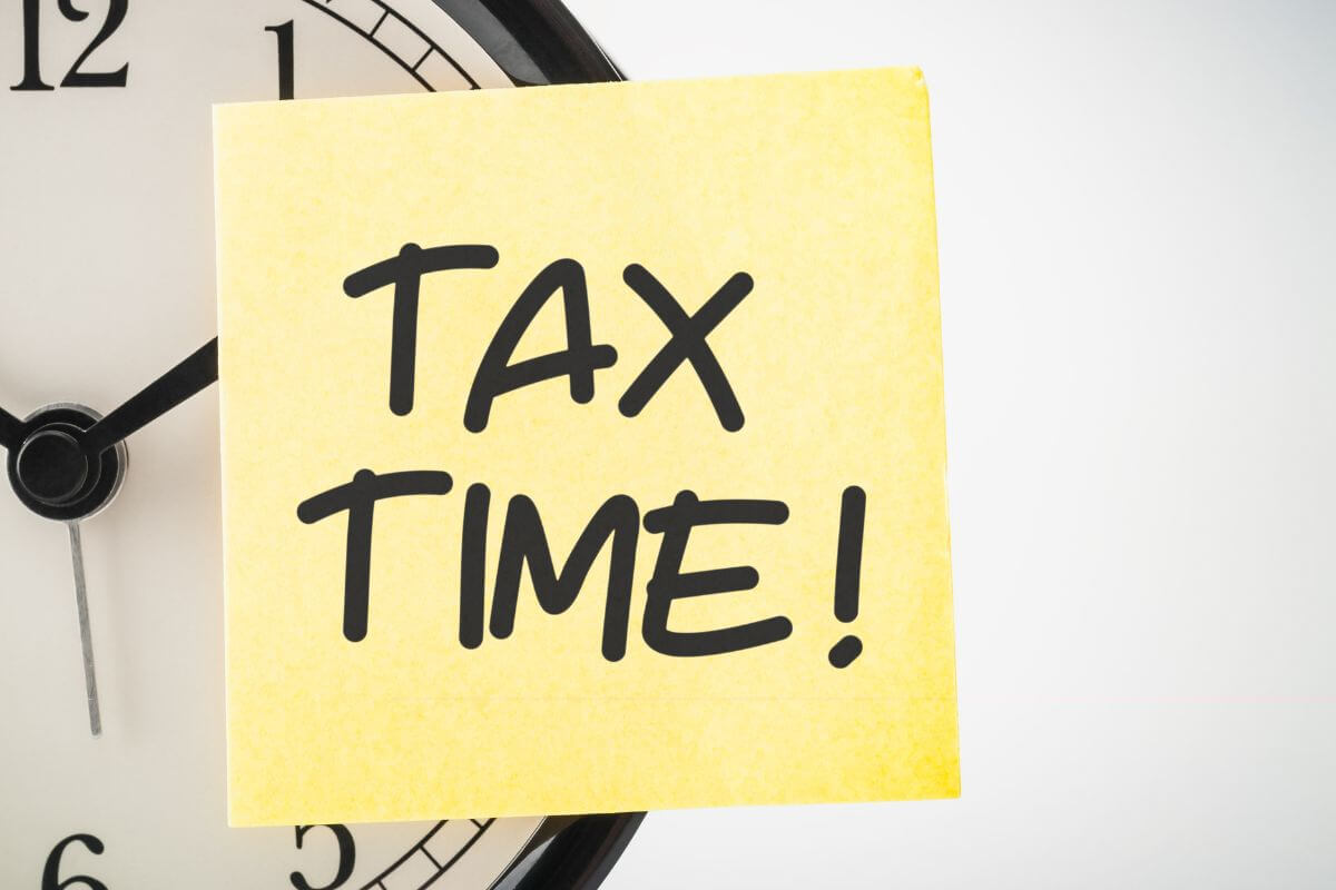 The photo shows a clock and a piece of paper with a note indicating that understanding and planning for your tax obligations ensures you pay what's due without unnecessary stress.