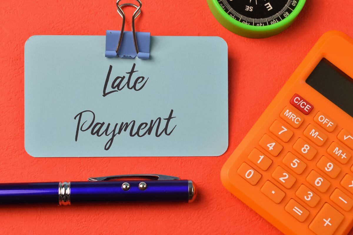 The photo shows a calculator, a pen, and a piece of paper with notes which means avoiding unnecessary fees keeps more of your money working for you.