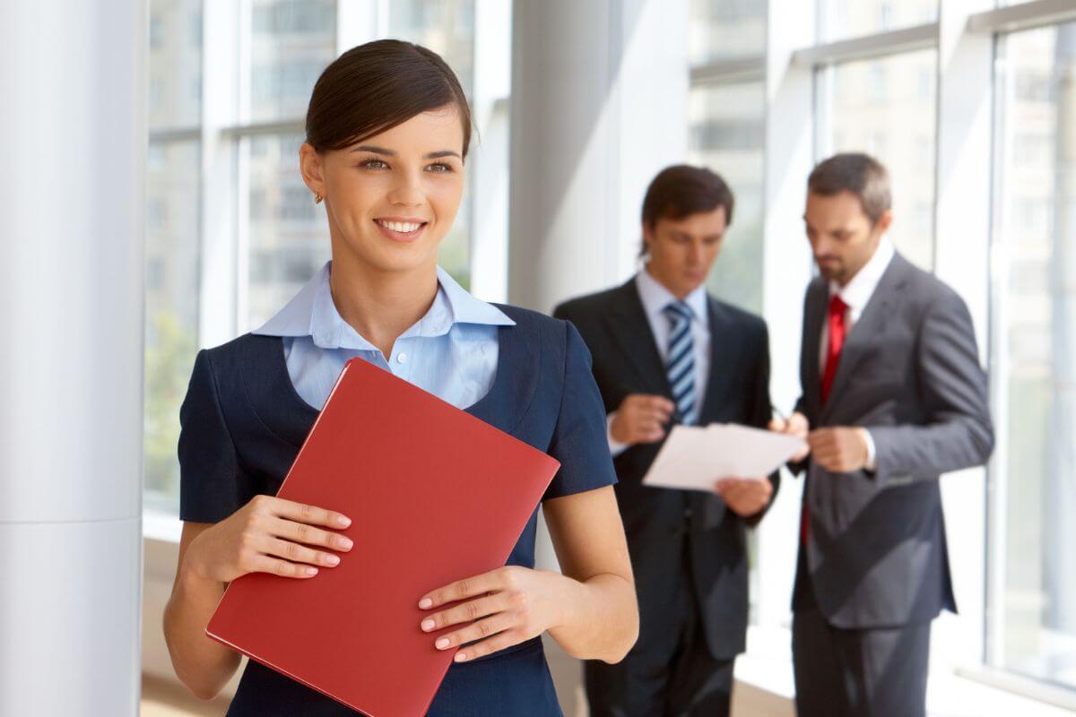 The picture tells about the men having a conversation and discussing the paper. A girl holding a red folder which means to take advantage of employer retirement plan matching to grow your retirement savings faster.