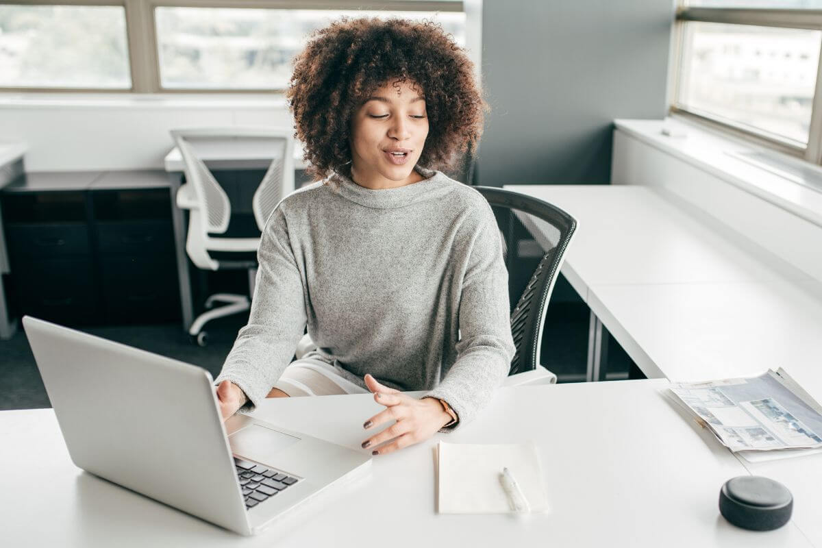 The picture of the papers on the table, a pen and a notebook, a girl using a laptop while explaining which means to offer virtual event planning and turn your talent into income.