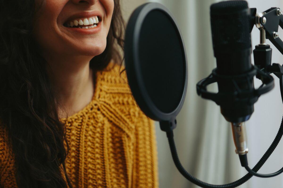 The image tells about a girl dubbing on the microphone recorder to offer voiceover work to make money with a side gig and earn at your own space.