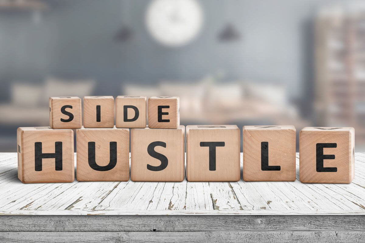 The picture shows wooden cubes with letters indicating to find the perfect side hustles for you to work less, earn extra income and move closer to financial independence.