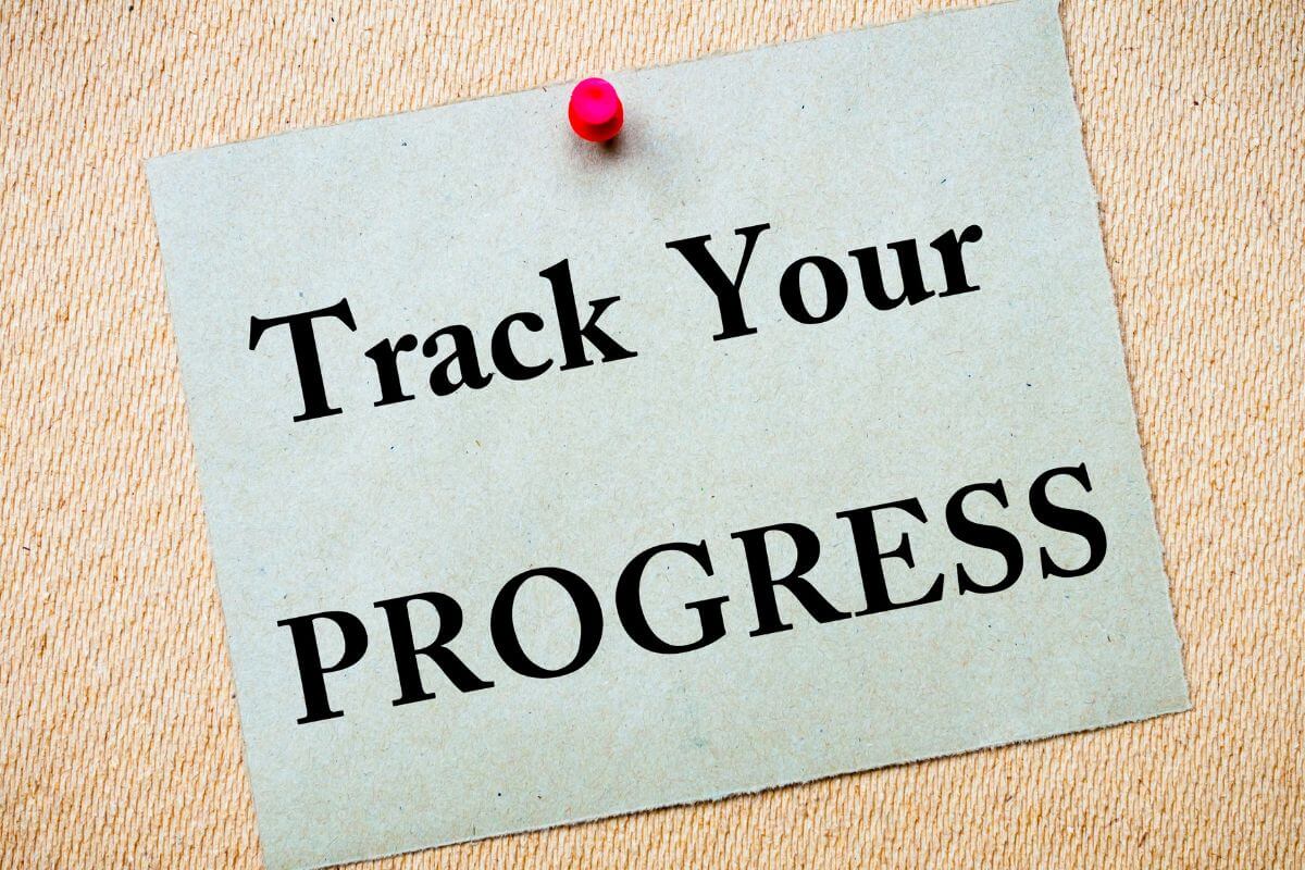 The picture shows a piece of paper with pin and notes indicating to track progress regularly helps you see what's working and what isn't.