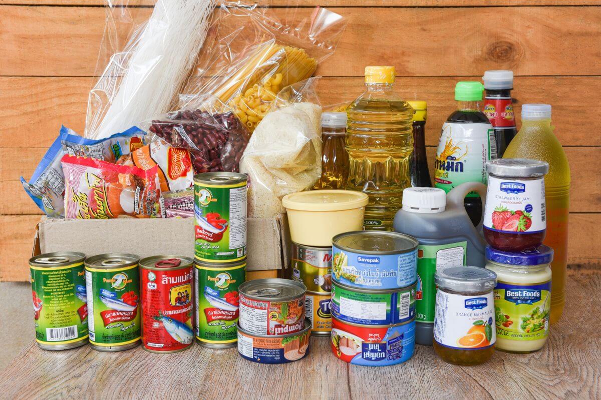 The photo shows canned goods, oils, pasta, and more essentials referring to buying in bulk for non-perishable items, a smart strategy for reducing your grocery bill over time.