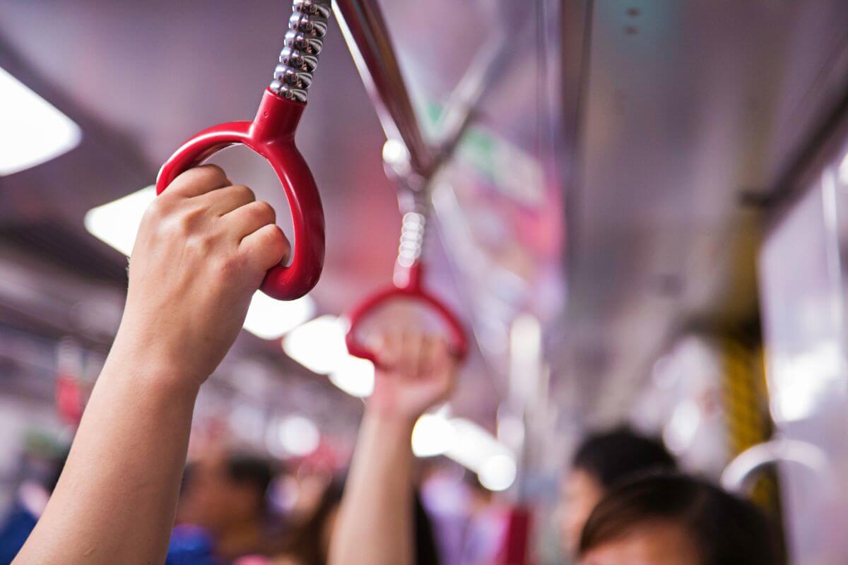 The picture tells about the hands of passengers preferring to use public transportation to cut down on gas costs and save on daily travel expenses.