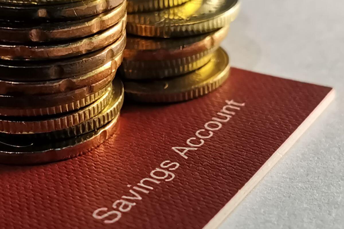 The photo shows stock coins and a bank book with notes referring to setting up a separate savings account for retirement savings only helps you stay focused on your goals.