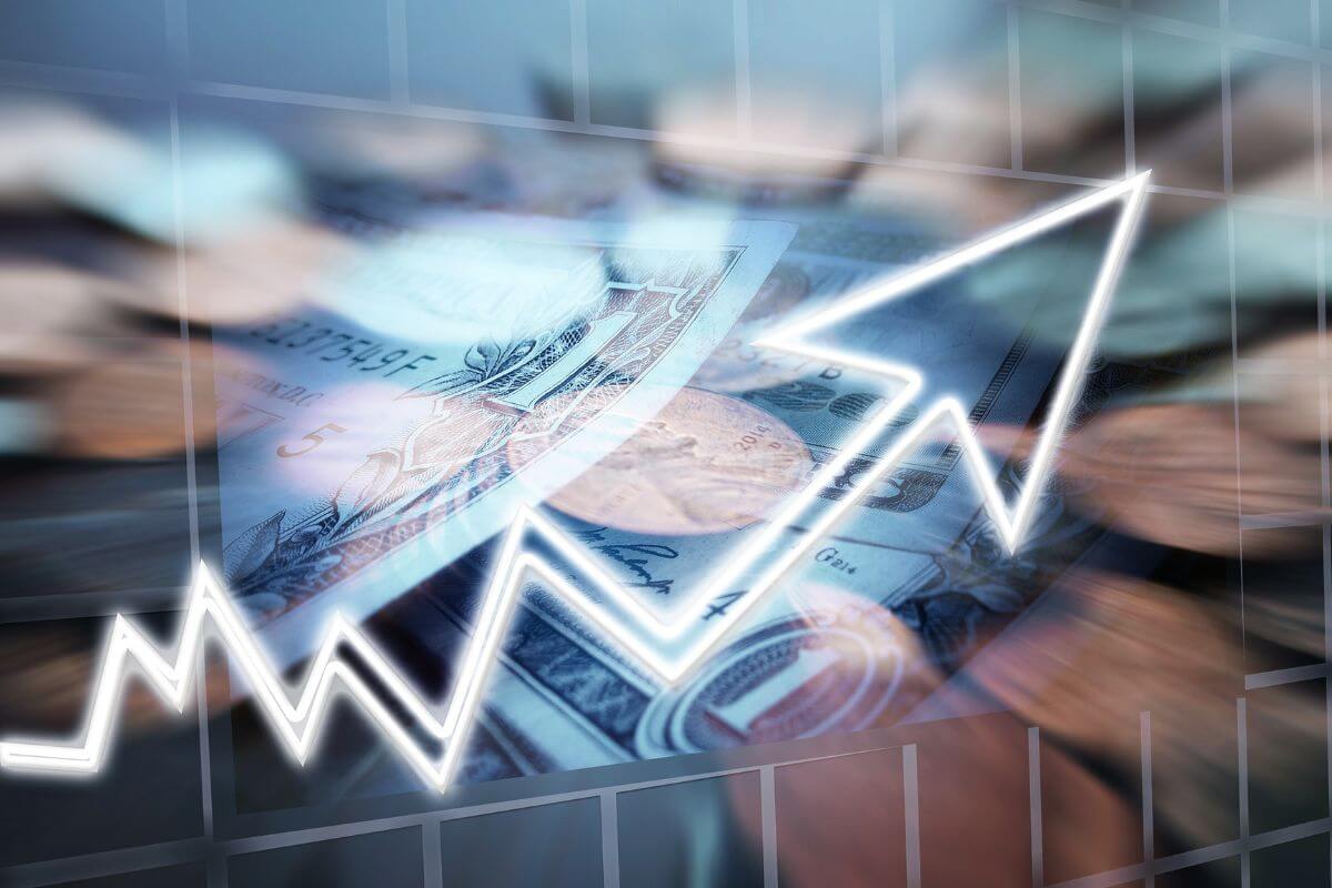 The photo shows dollar bills and coins, and the rising arrow concept refers to taking advantage of low-cost investment options to reduce fees and keep more of your money working for you.
