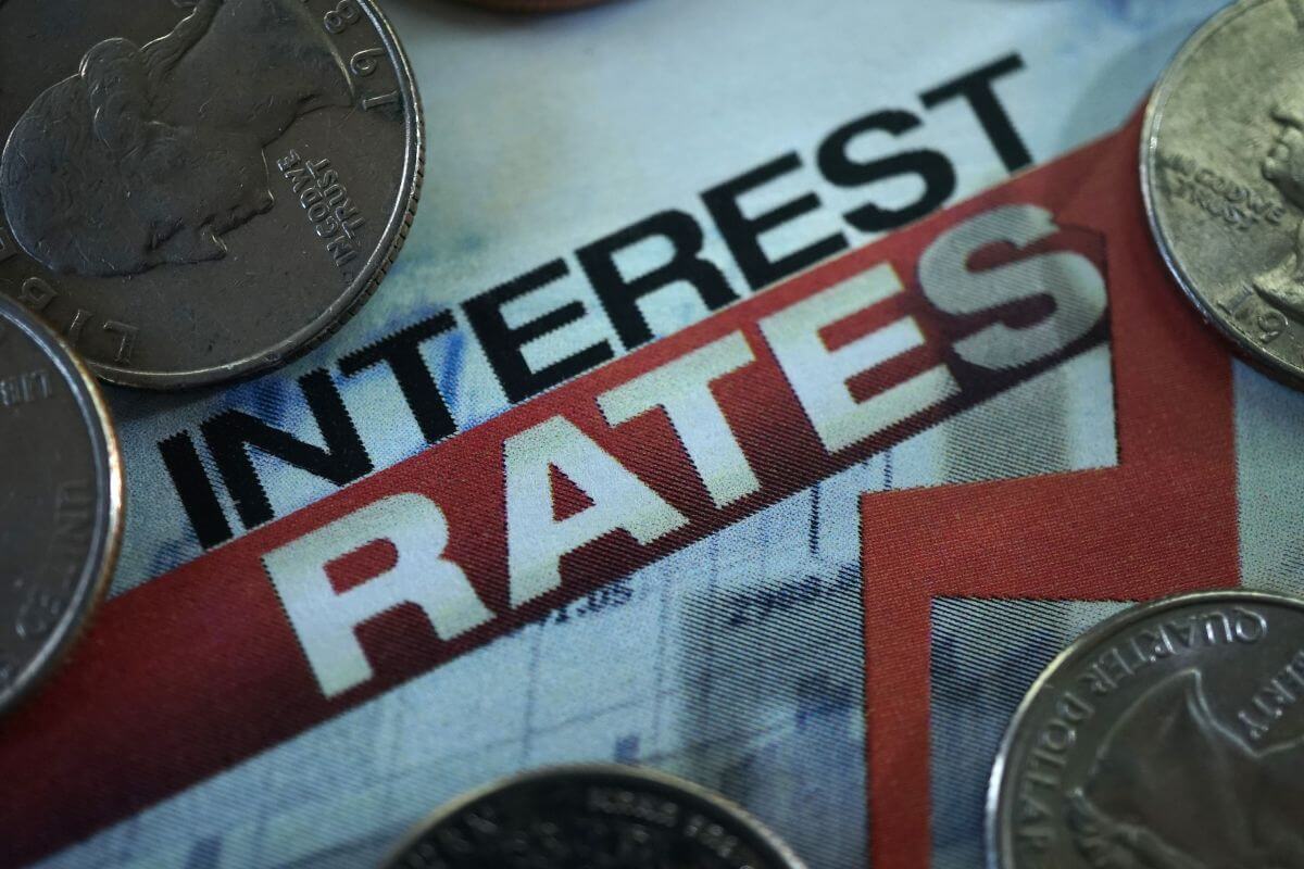 The photo shows coins and a paper with notes and graphs referring to negotiate lower interest rates saves you money and can make your debt feel more manageable.