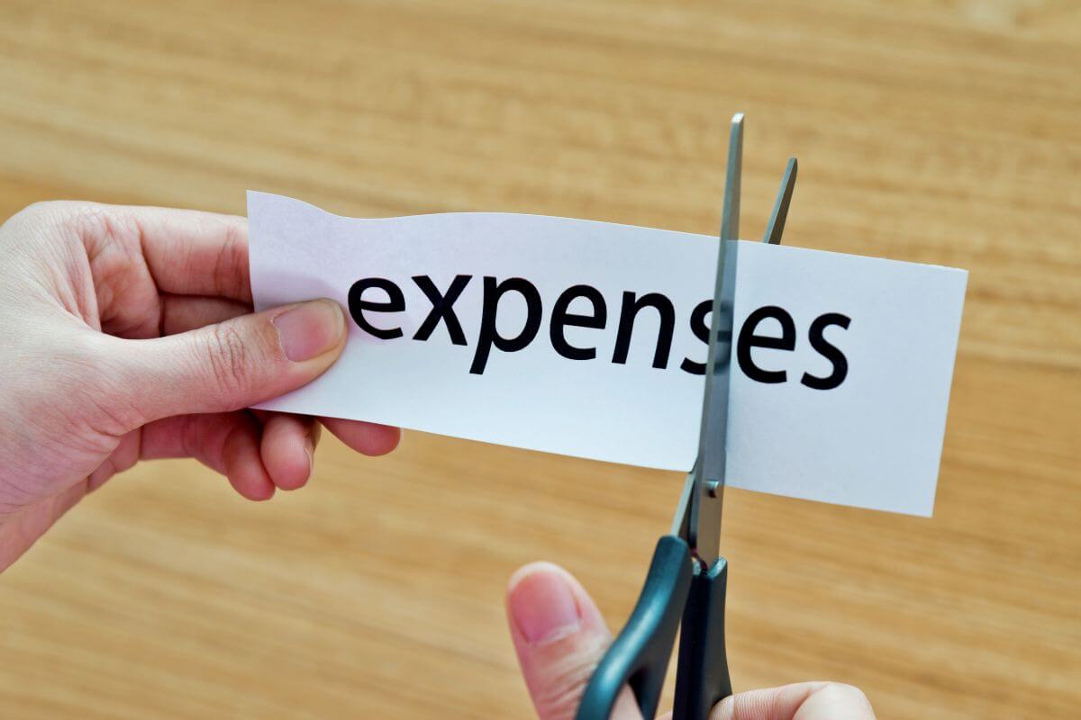 The image shows a girl's hand cutting the paper with a note referring to making sure not to charge these expenses to protect your financial health.