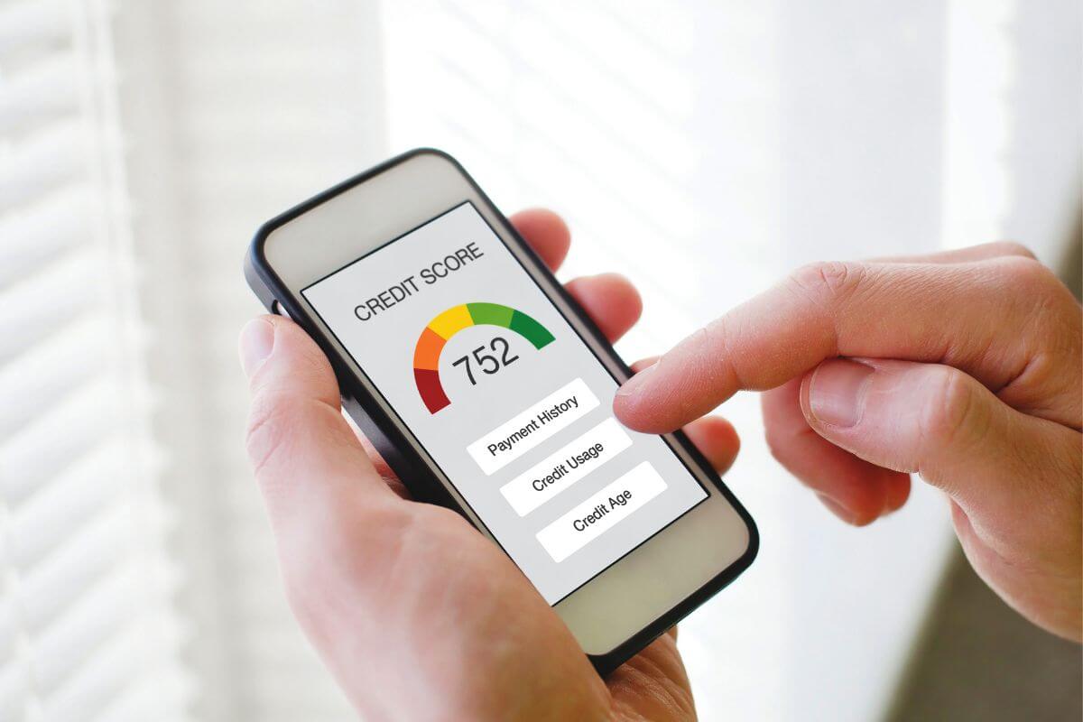 The picture of a man's hand using a smartphone with a screen display refers to building good credit by making timely payments helps you build a solid credit history for future big purchases.