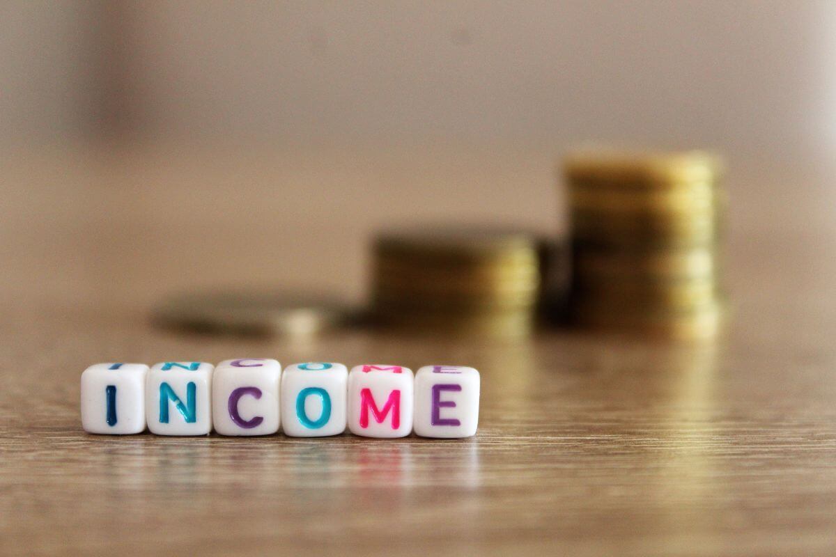 The image tells about coin stocks and white cubes with letters which means not tracking income can lead to overspending and poor money choices. 