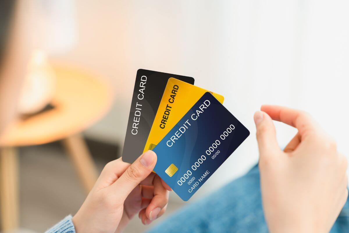 The image shows a girl's hand holding cards which refers to relying on credit cards can lead to high-interest debt.