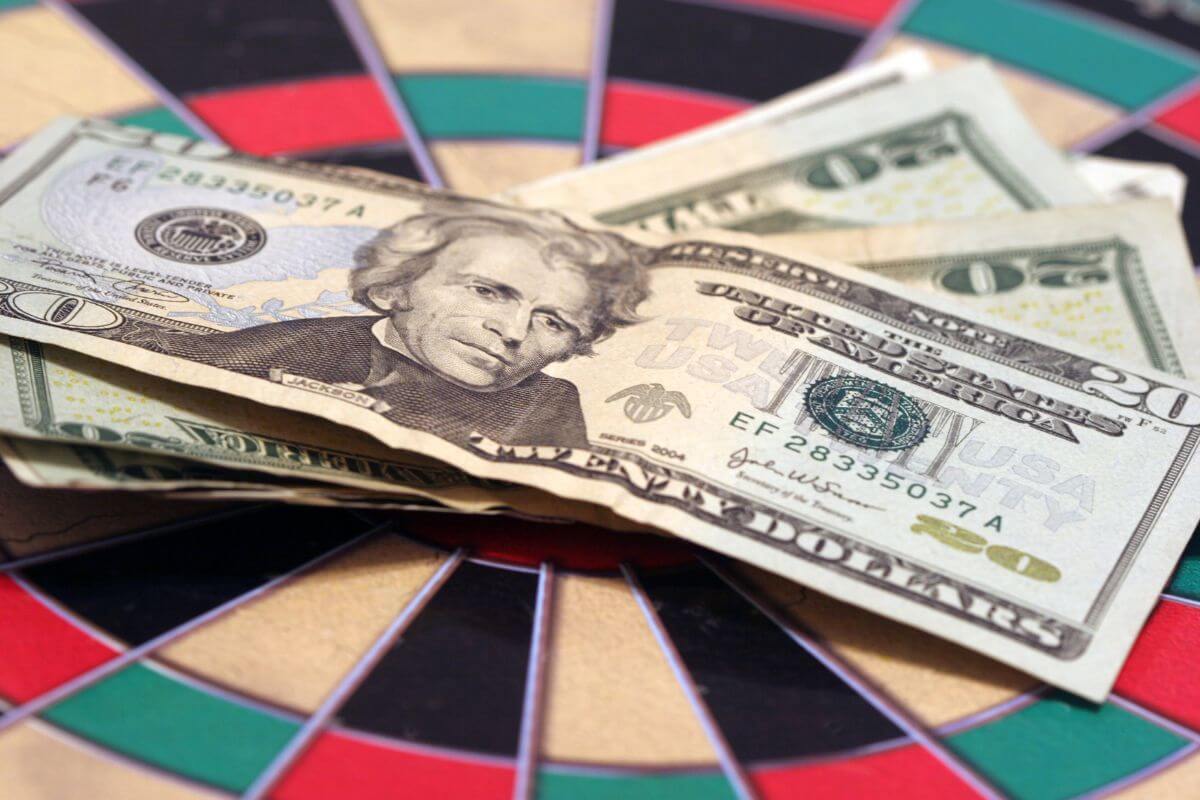 The photo tells about dollar bills on the colorful circle thing indicating to having no financial goals will easy to spend on things that don't matter.