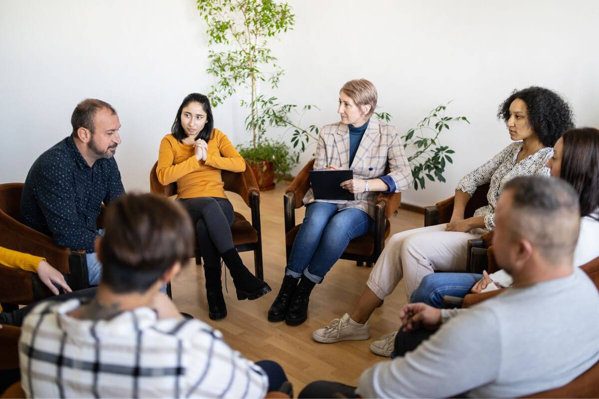The image shows a group of people forming a circle indicating to take advantage of the buy-nothing group to save while decluttering your home or helping others.