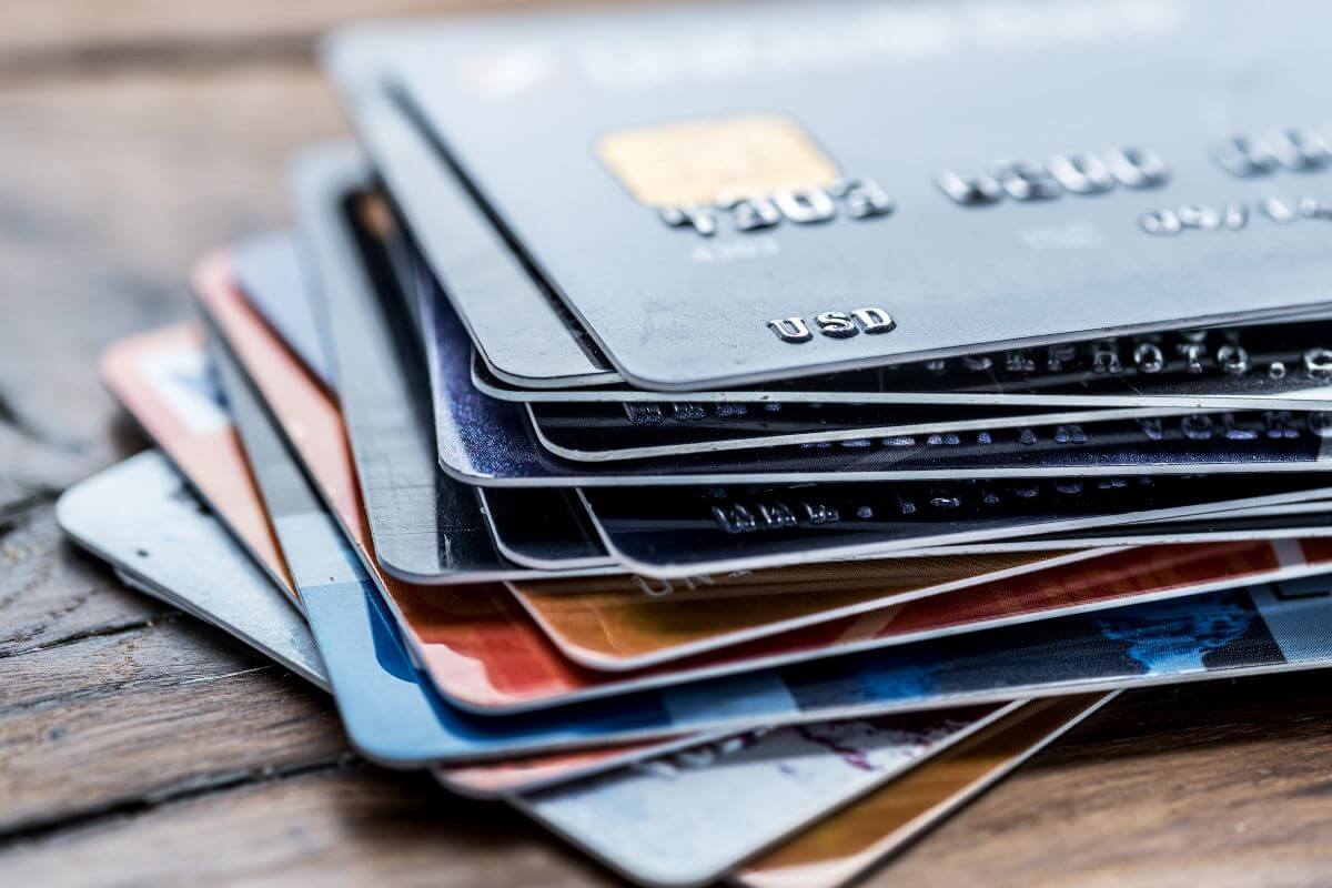 The picture shows credit cards on the wooden table indicating to freeze your credit cards in a block of ice to give yourself time to rethink purchases.