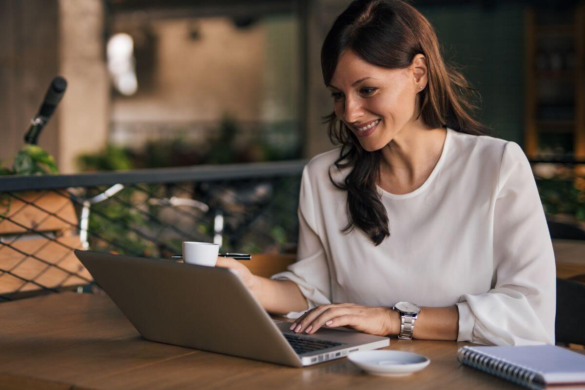 The image of a notebook, a plate, and a girl using a laptop while having a coffee refers to quizzing yourself about being financially sound to see where you stand.