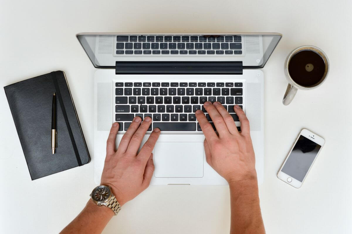 The image tells about a man's hand holding a coin, numbers on the screen, a rising arrow, and a note that refers to starting with low-cost index funds that provide instant diversification without the stress of picking individual stocks.
