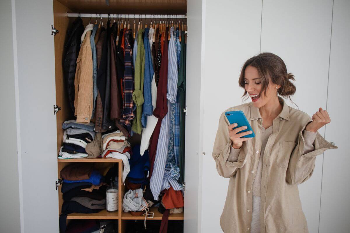 The picture of a wardrobe with clothes and a girl posting them online to sell unused clothes or items and make money from decluttering.