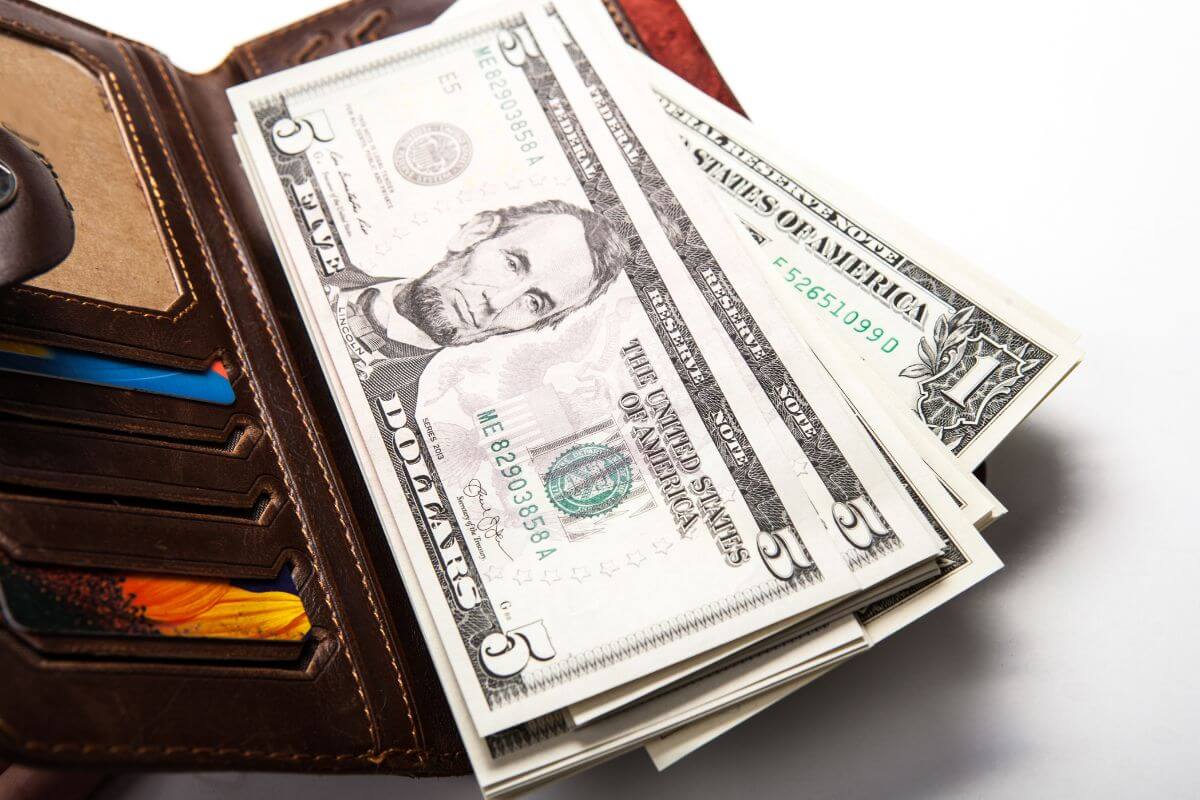 The picture of a wallet with cards and dollar bills refers to setting spending limits for each category based on priorities for better budgeting.