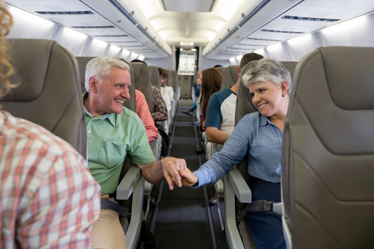 The picture of senior passengers inside a plane together with the other passenger indicating to use senior discounts for flights to save money on accommodations, transportation, and a more without breaking a bank.