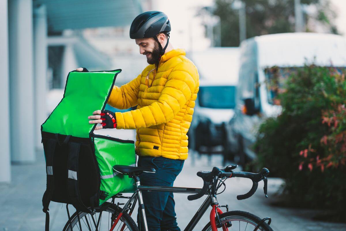 The image tells about a man opening the food box for delivery which refers to finding ways to increase income like side jobs that can help you pay off debt faster and grow your savings.