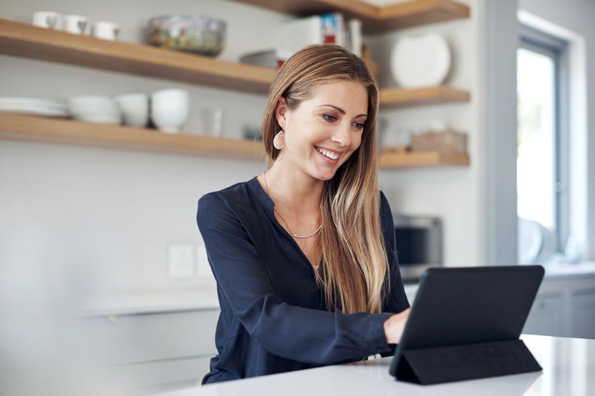 The picture of a girl using a tablet device at home refers to managing social media accounts for businesses, which is a flexible and rewarding way to earn money.